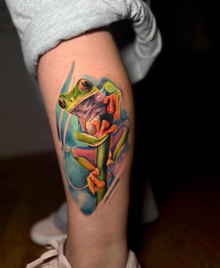 Colourful tree frog tattoo on a forearm