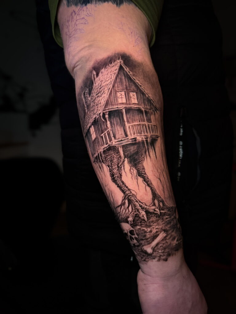 Black and grey tattoo of a house on clawed legs